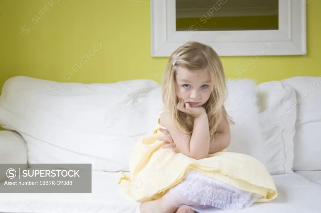 Little girl pouting on a couch