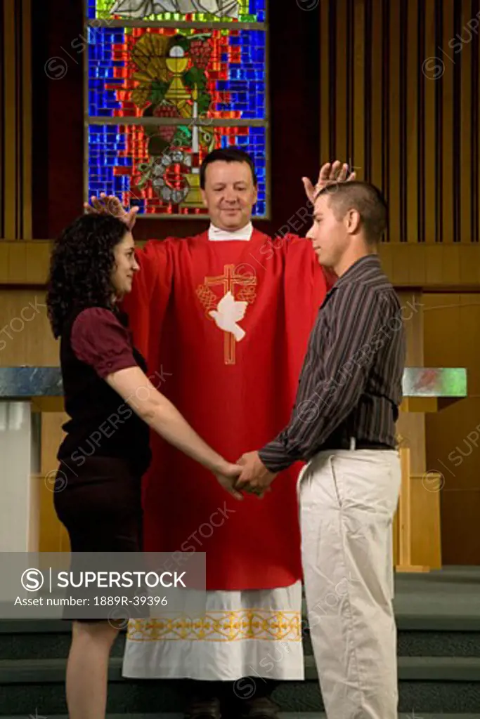 Priest praying for a couple