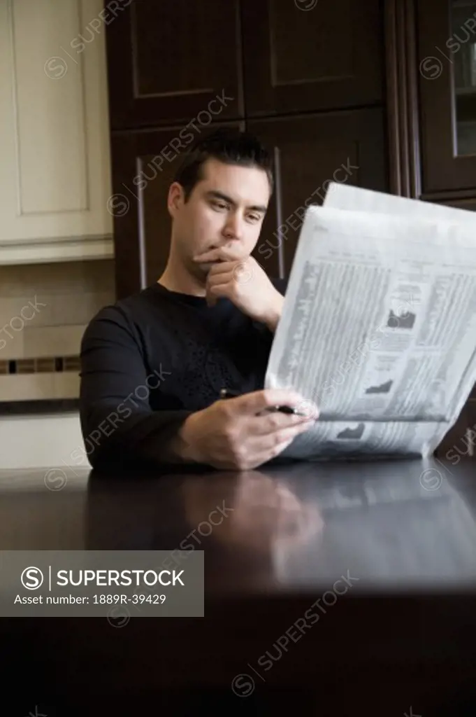 Man reading the newspaper at home