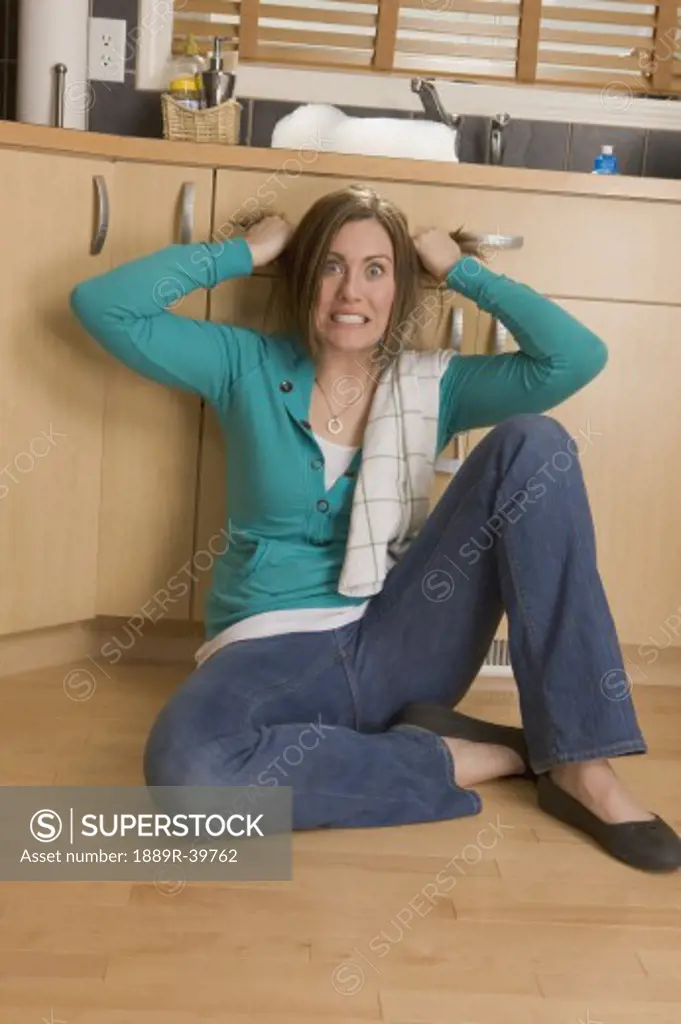 Woman sitting on the floor of the kitchen