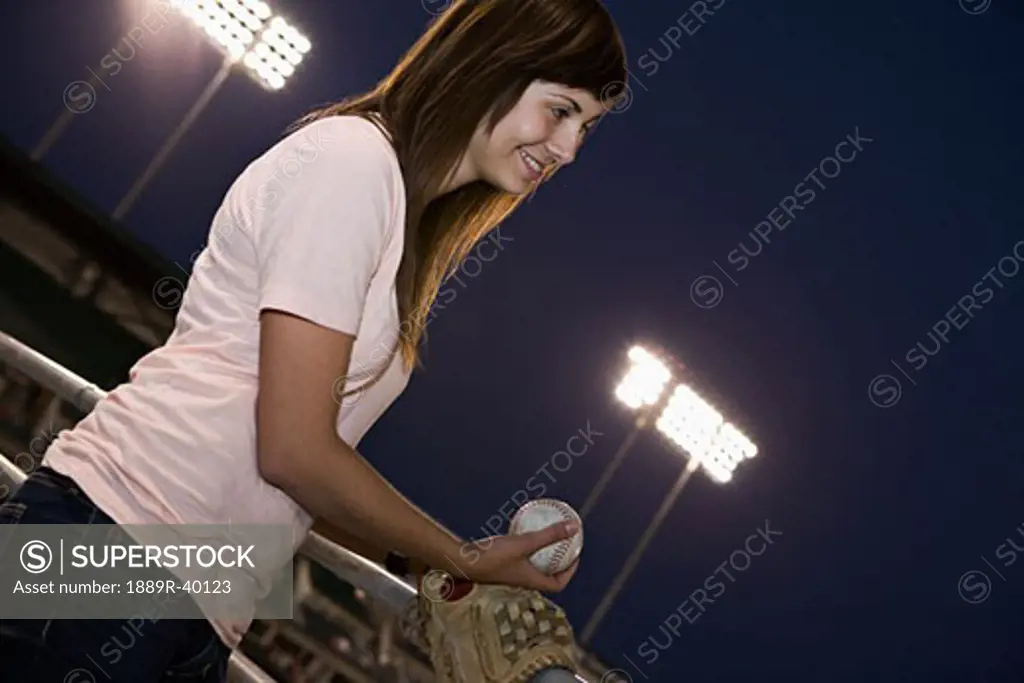 Young adult woman pitching at a baseball game