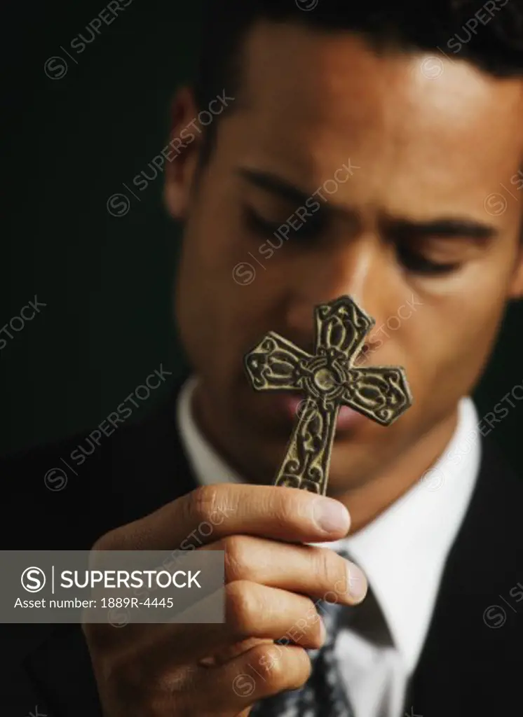 Businessman holding out a cross