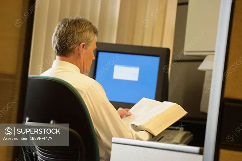 Businessman reading Bible in office
