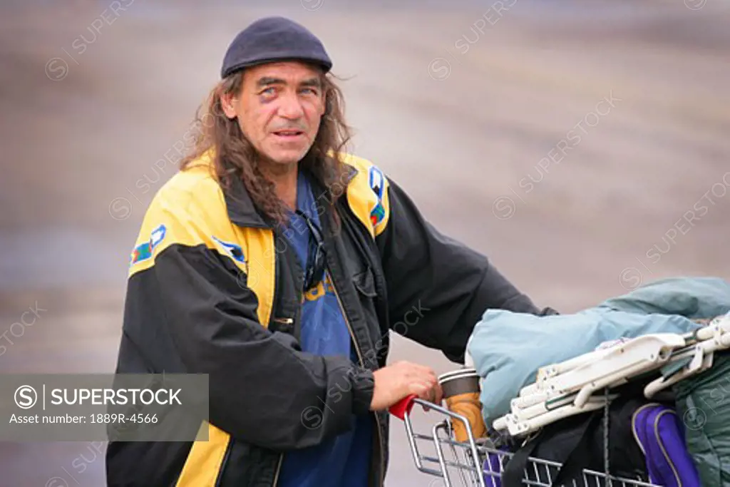 A homeless with his life in a shopping basket
