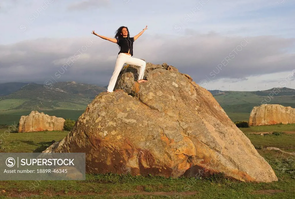 Woman stretching on a rock