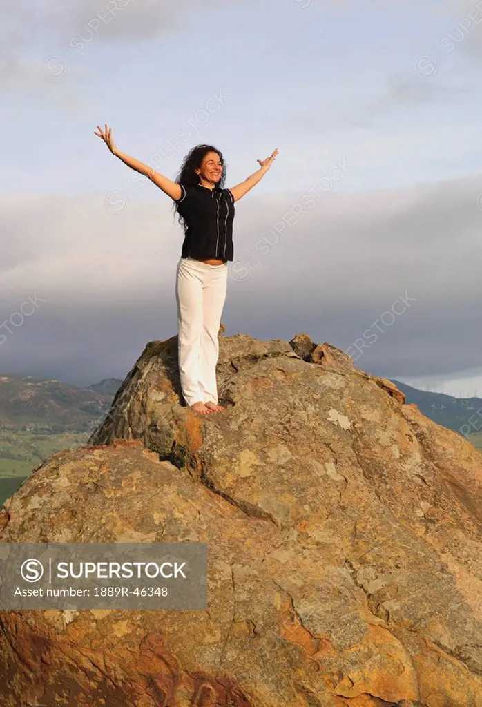 Woman on mountain peak with arms raised