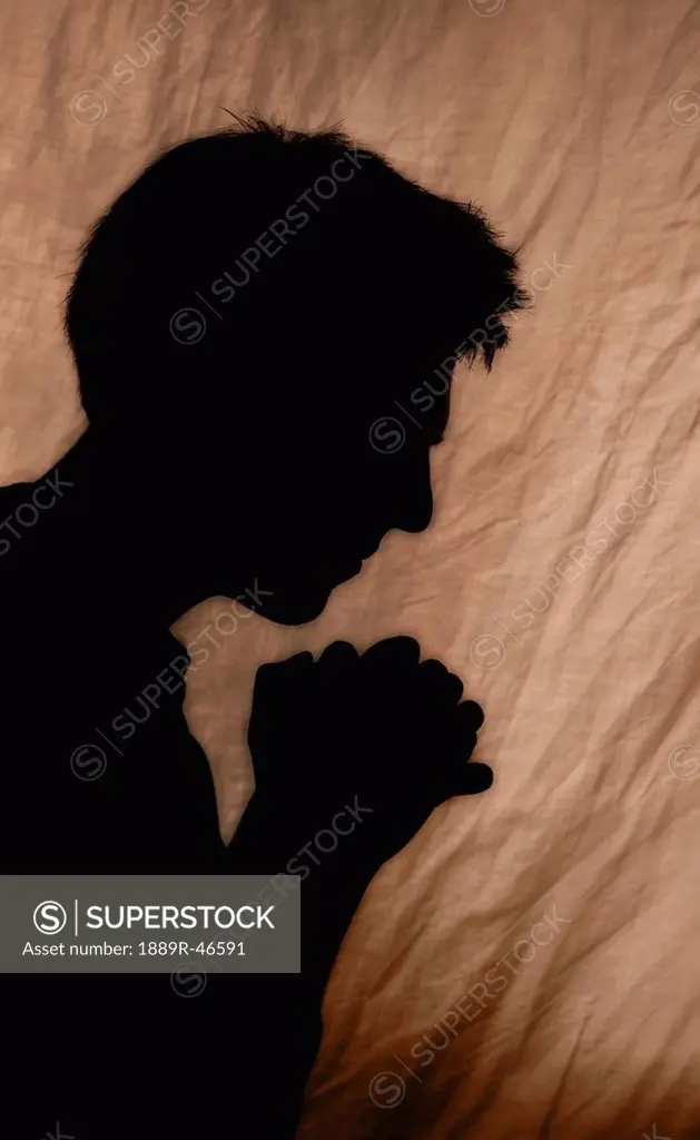 Shadow of man praying