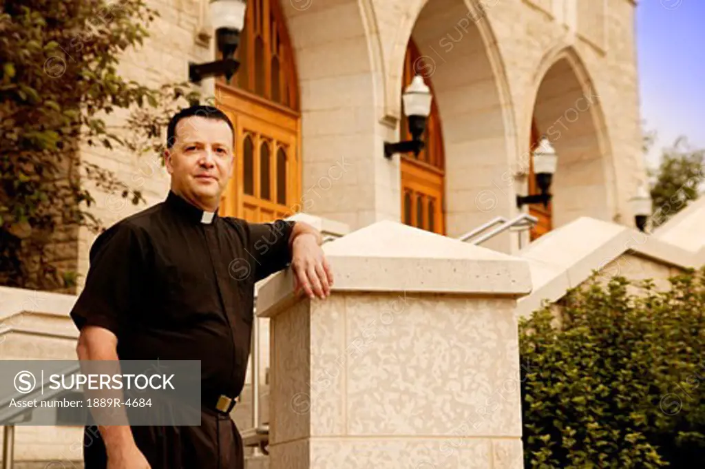 Priest standing outside a church