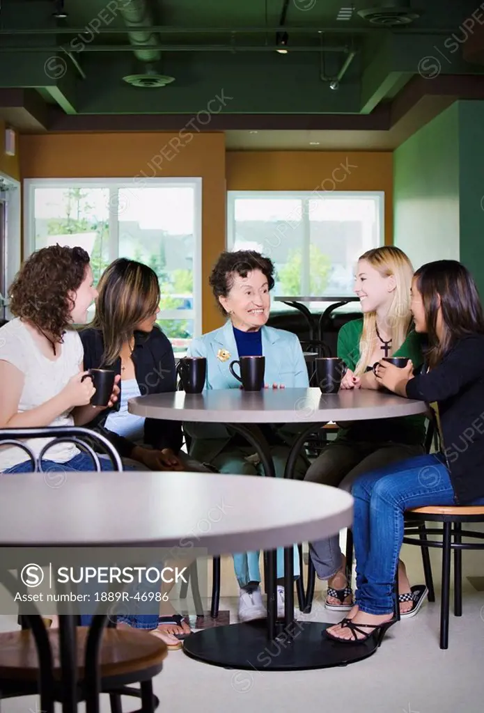 Older woman talking to group of young friends