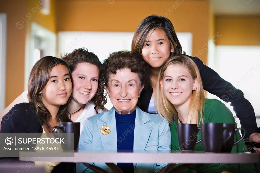 Elderly woman surrounded by young friends