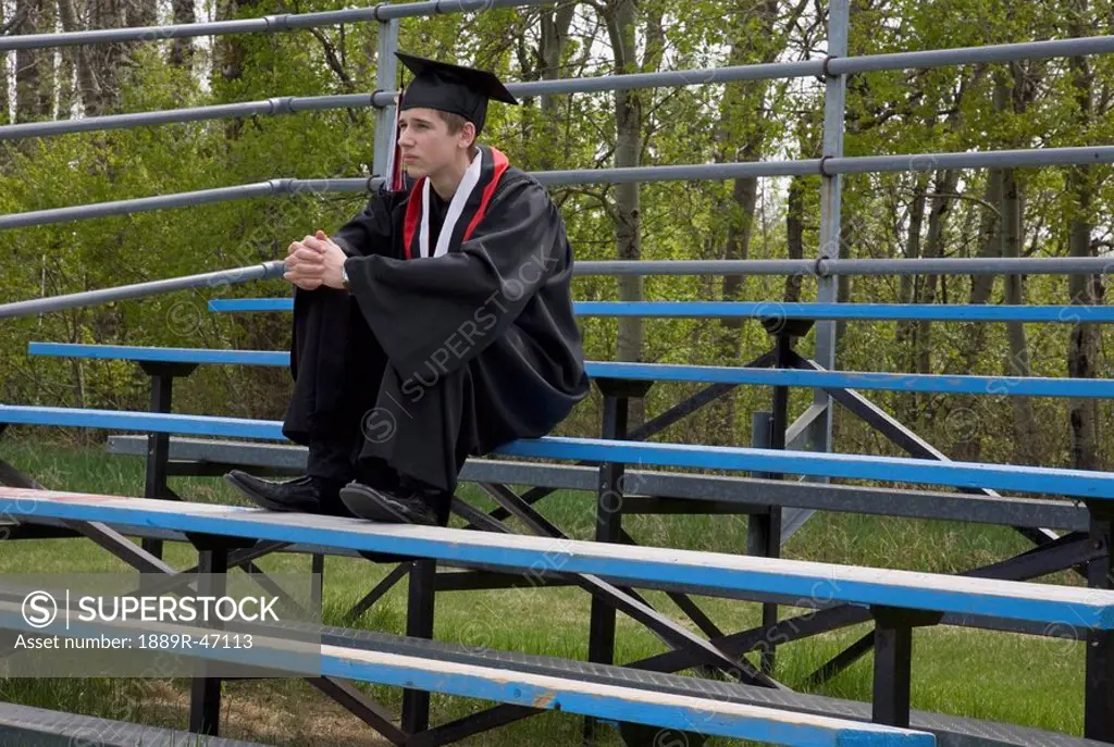 Graduate sitting on bleachers