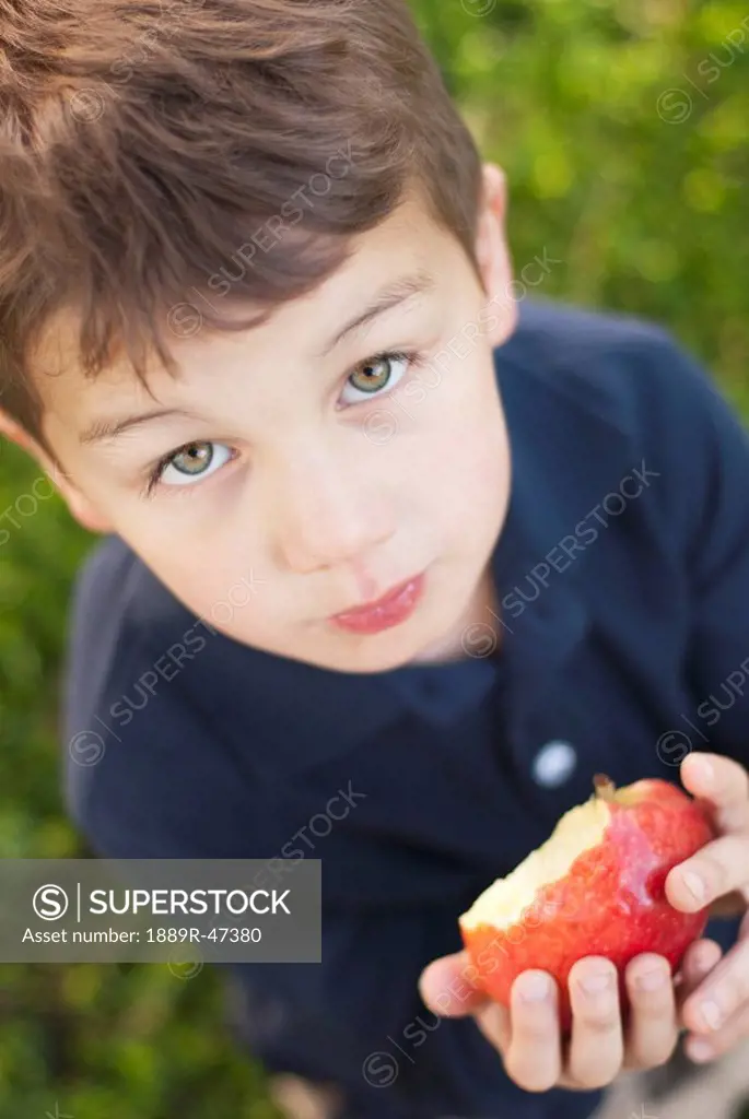 Five year old boy eating an apple