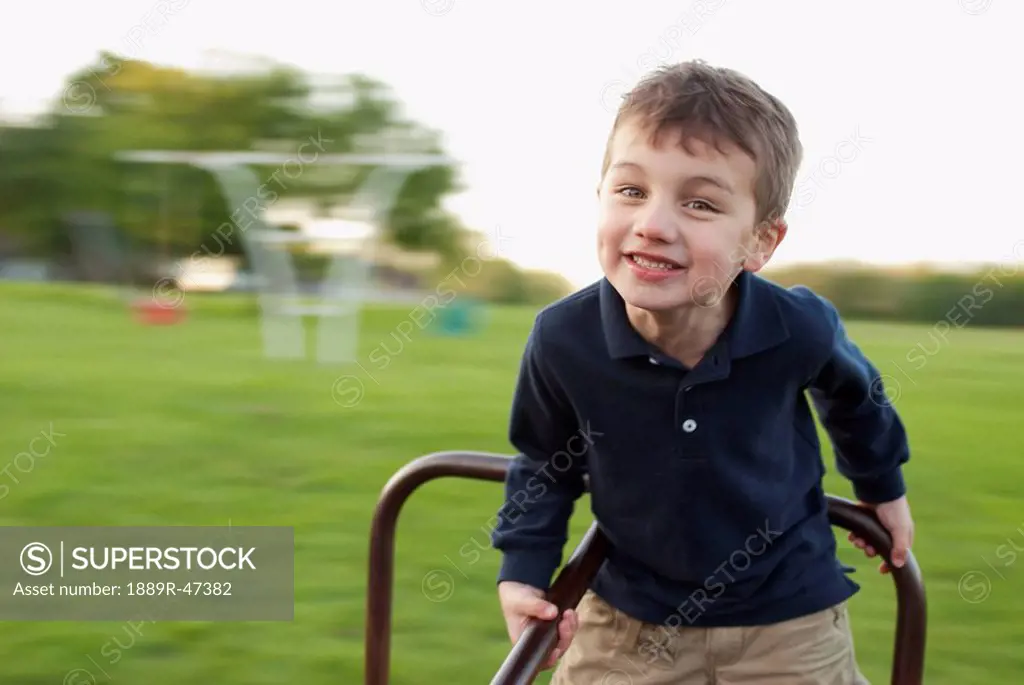 Five year old boy playing on a merry_go_round