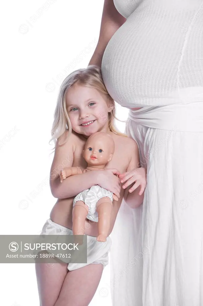 Daughter leaning on her mother´s pregnant belly