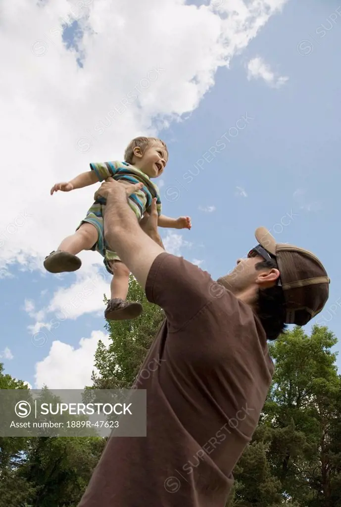Father holding up son
