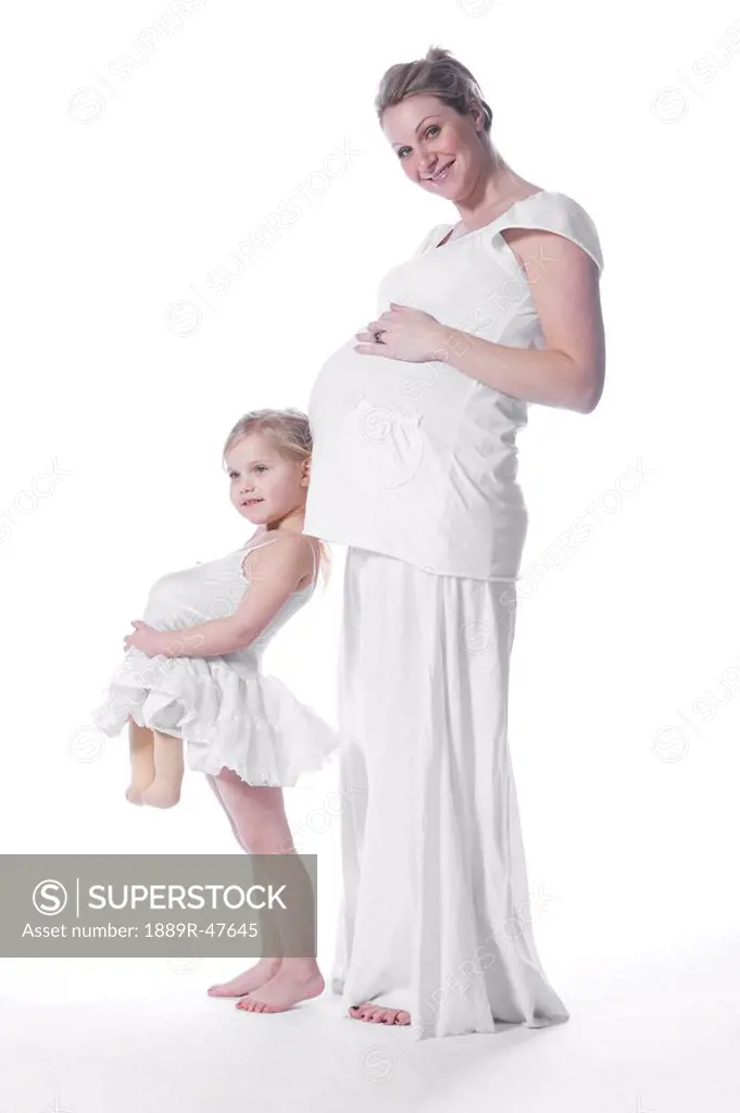 Pregnant mother and daughter pretending to be pregnant
