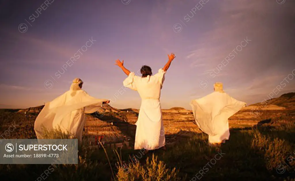 Three angelic people on top of mountains