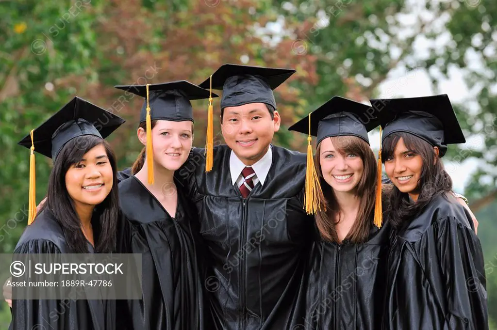 Diverse university graduates outside together