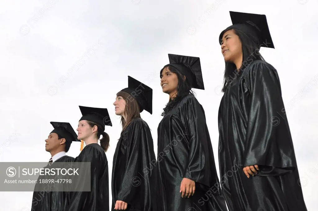 Diverse university graduates outside together