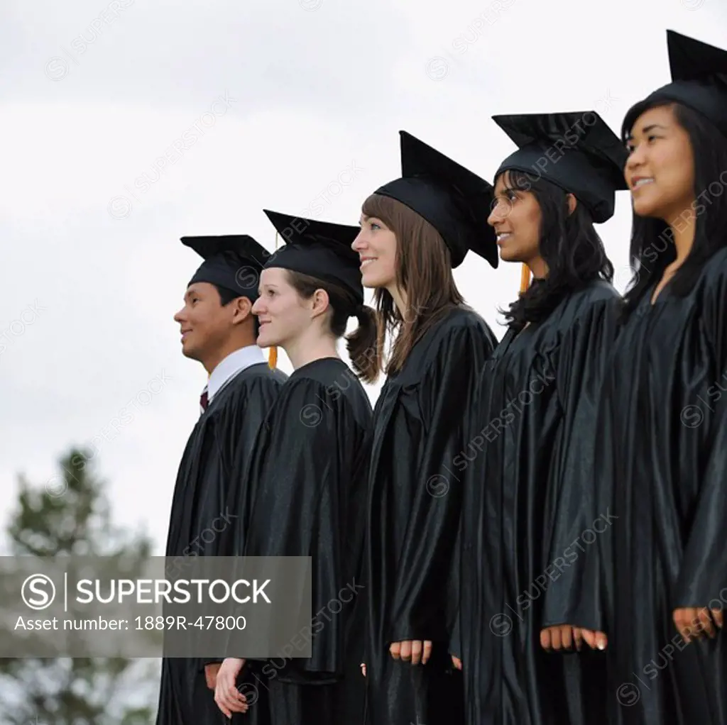 Diverse university graduates outside together