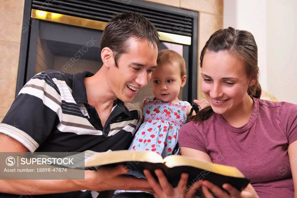 A young Christian family reading the Bible together