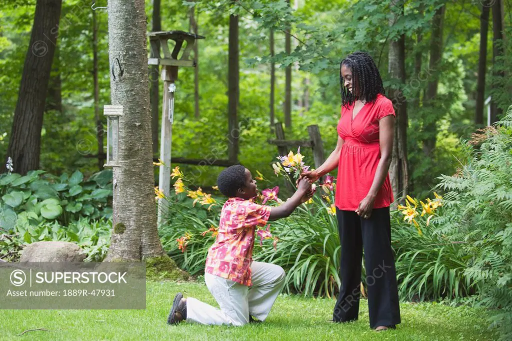 A boy giving his mother flowers