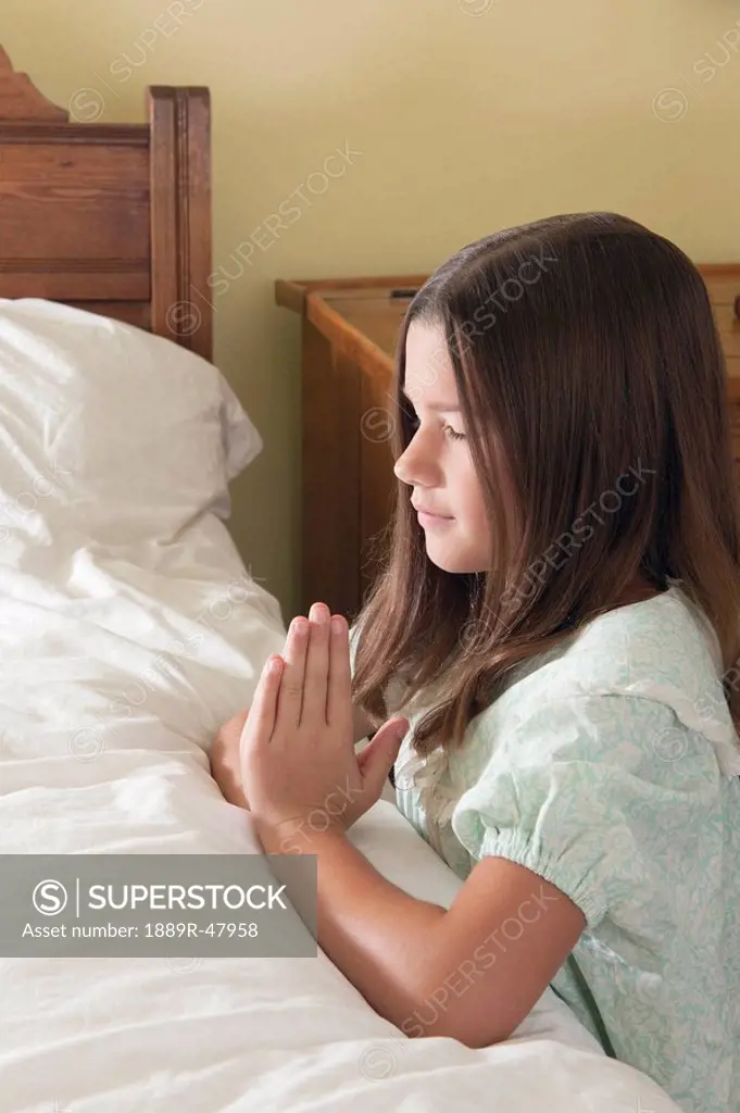 A young girl doing her bedtime prayers