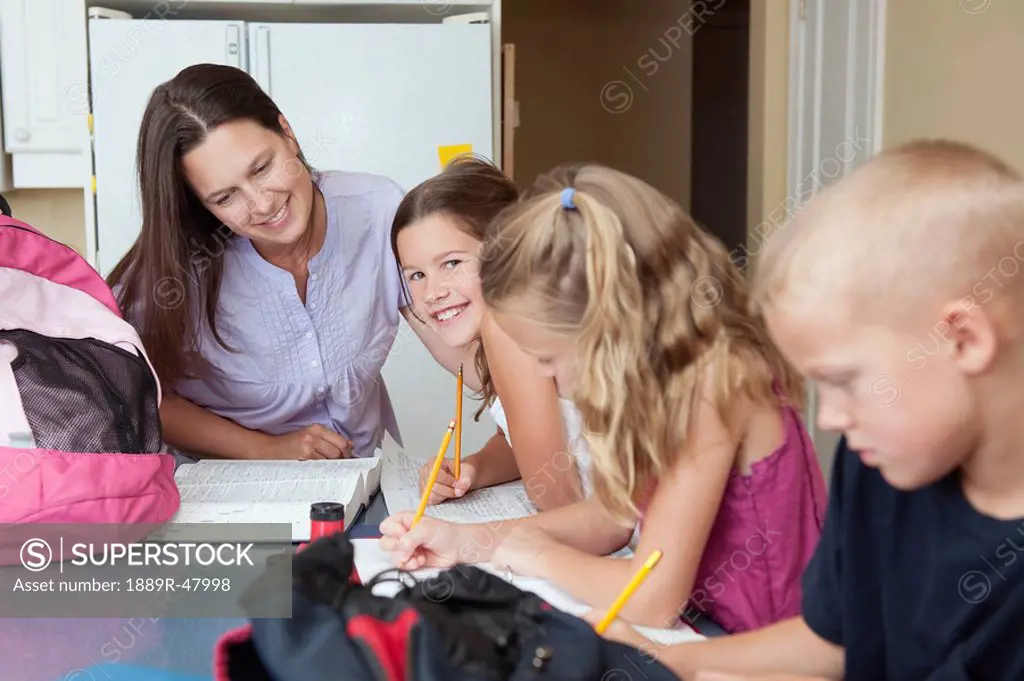 A mother helping her children with their homework