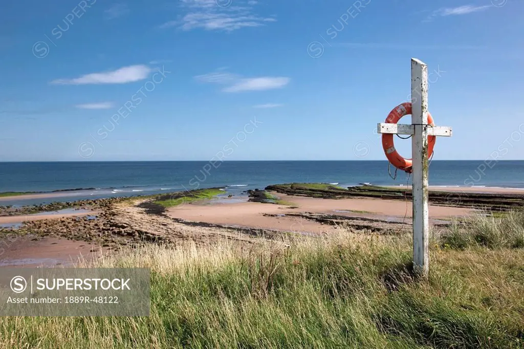 Life ring on beach, Northumberland, England
