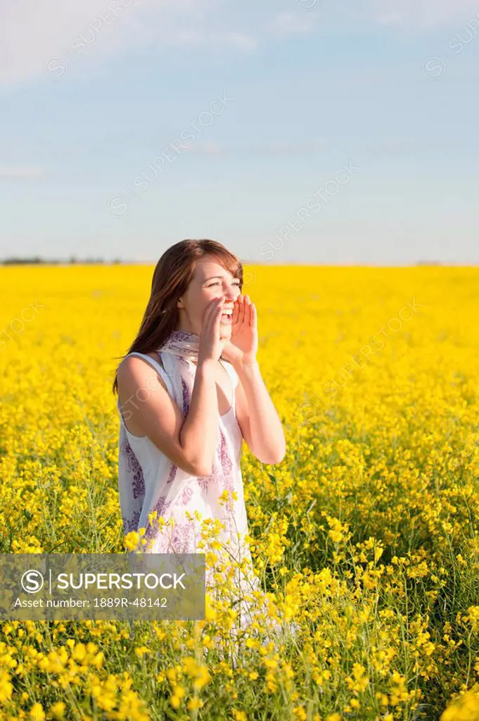 A young woman in a canola field