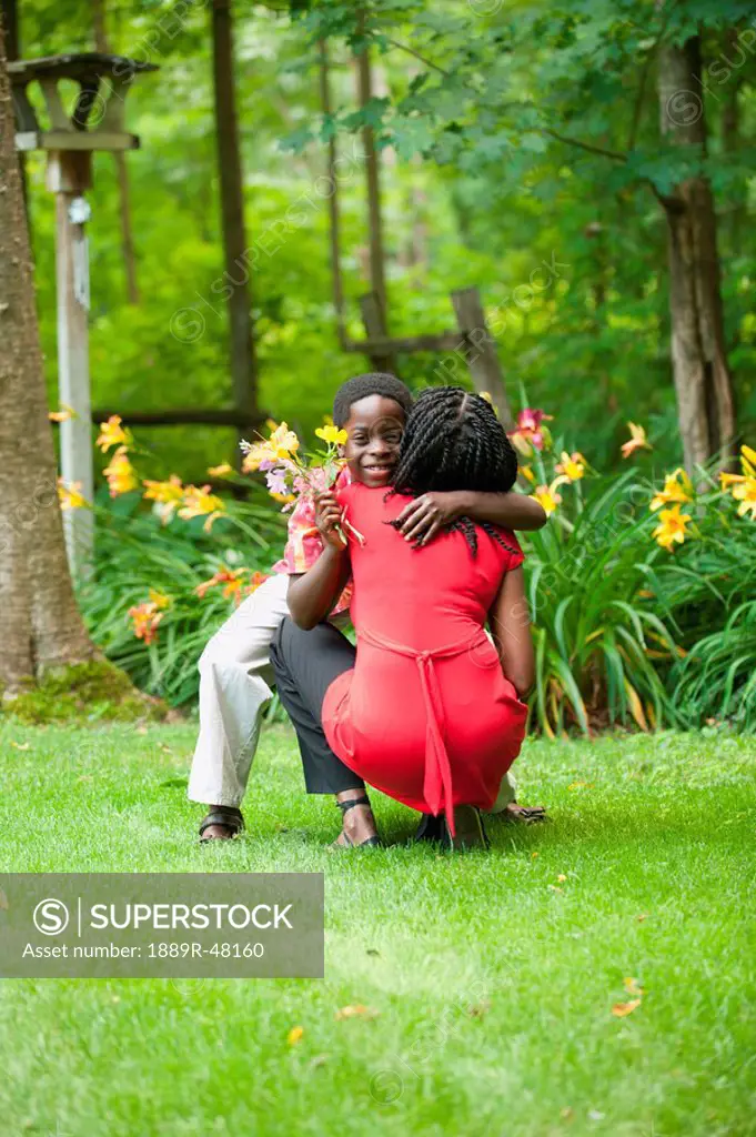 A boy giving his mother flowers