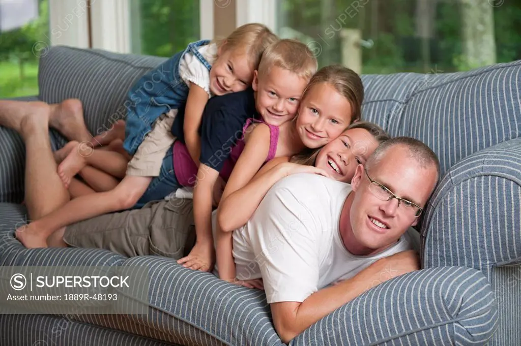 Children with father lying on couch