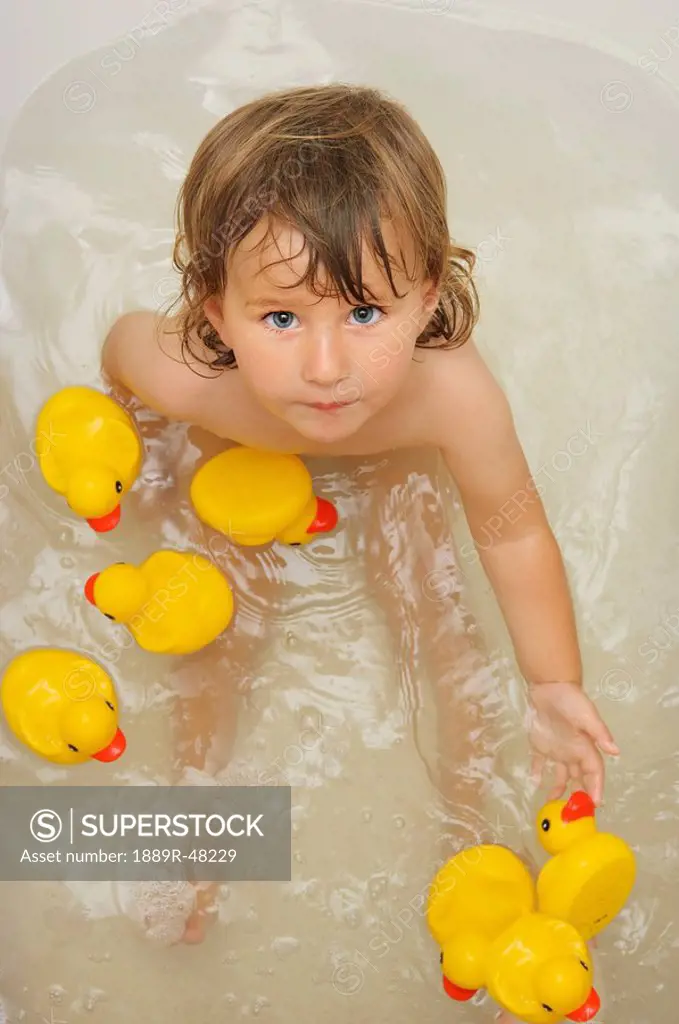 Girl in the bathtub with rubber ducks