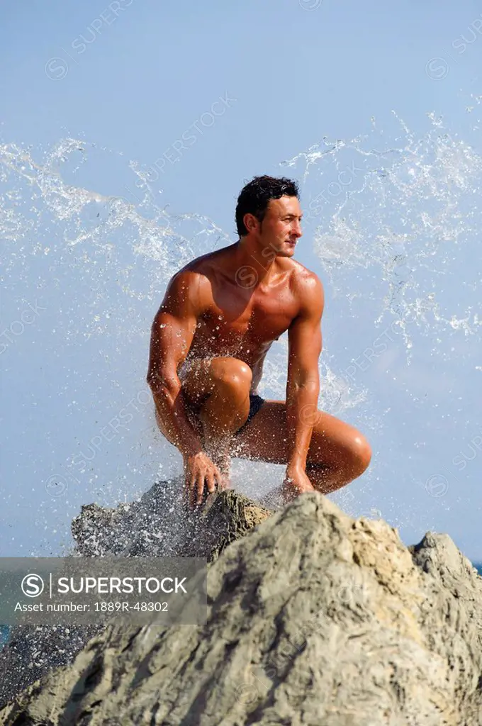 Man on a rock in his bathing suit