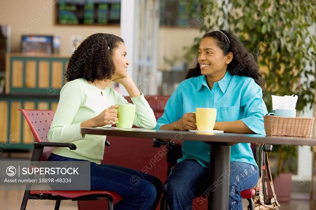 Hispanic mother and daughter in coffee shop