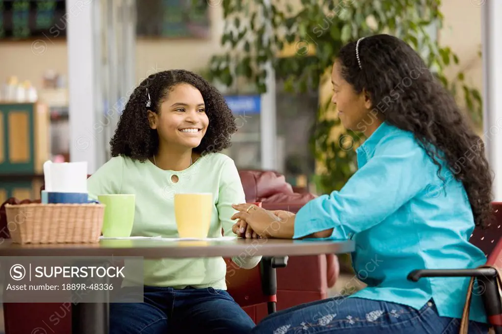 Hispanic mother and daughter in coffee shop