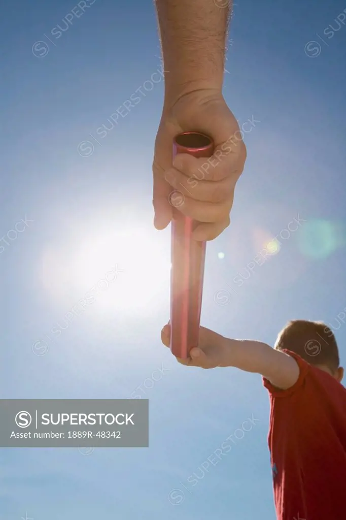Father handing off a baton to his son