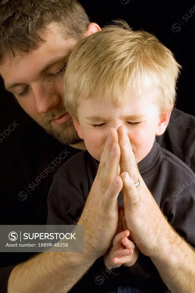 Father praying with son