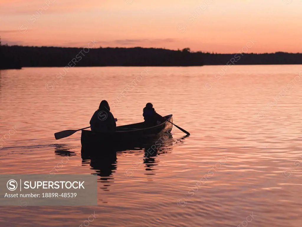 Rowing on lake at sunset, Lake of the Woods, Ontario, Canada