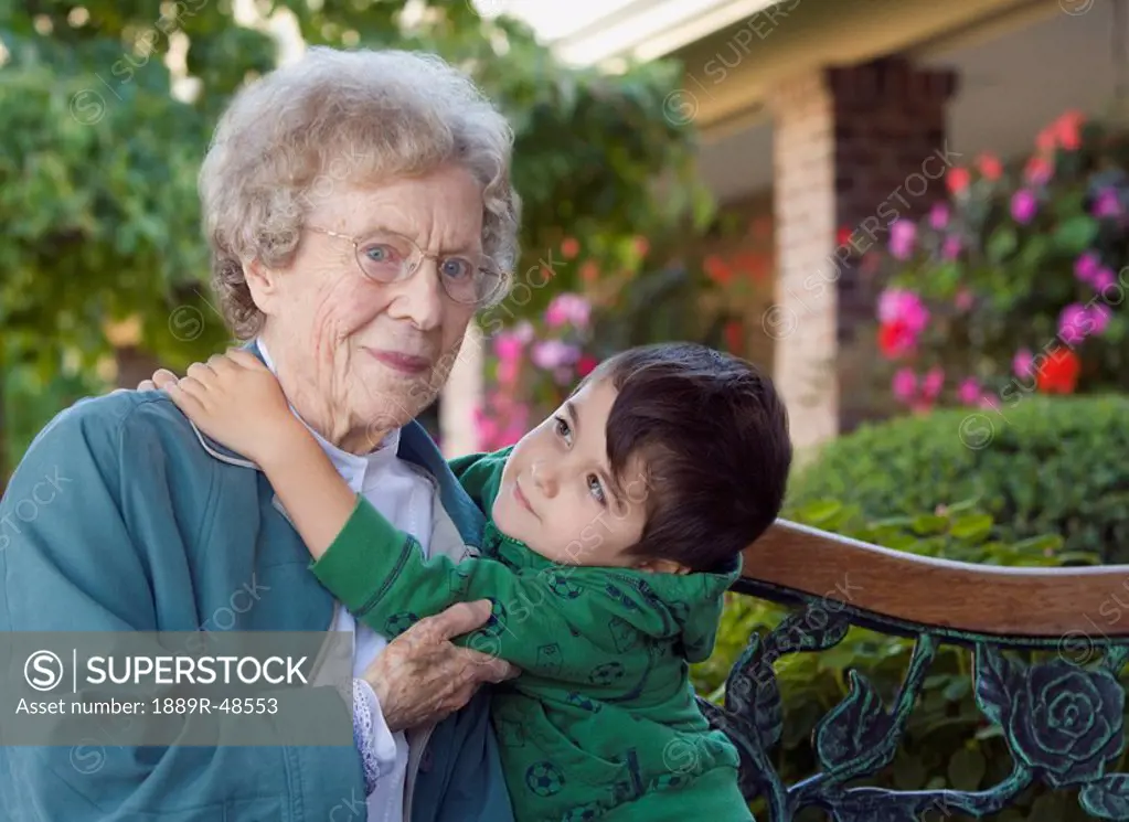Outdoor portrait of grandmother and grandchild embracing