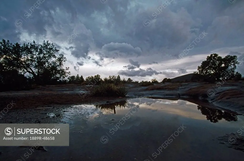 Rain pool and storm clouds, Toroweap area of Grand Canyon, Arizona, USA