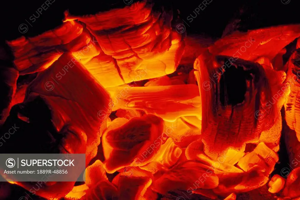 Hot coals from wood fire glow yellow to red to orange