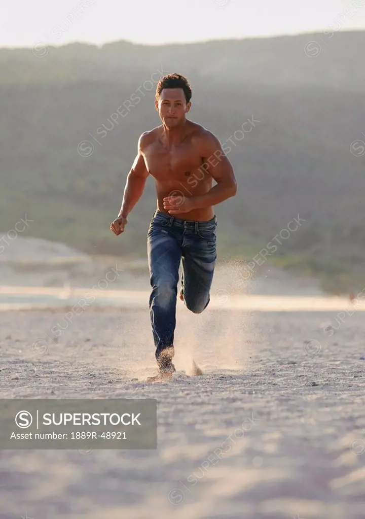 Young man running on the beach