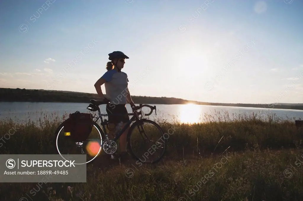 Woman with bike along a lake