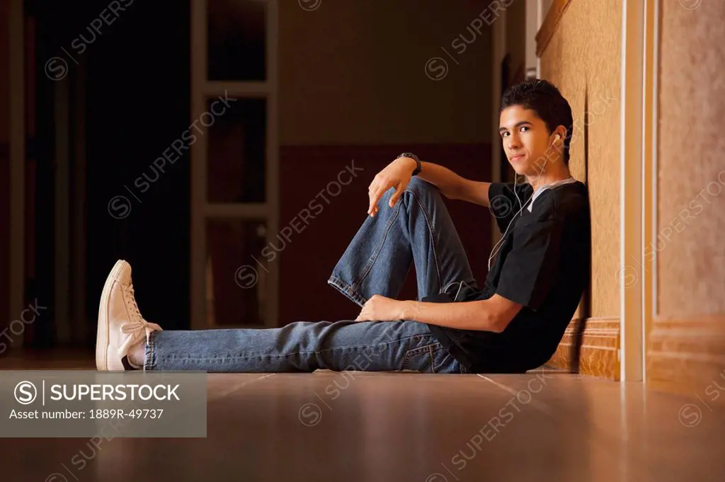 Teenage boy sitting on the floor