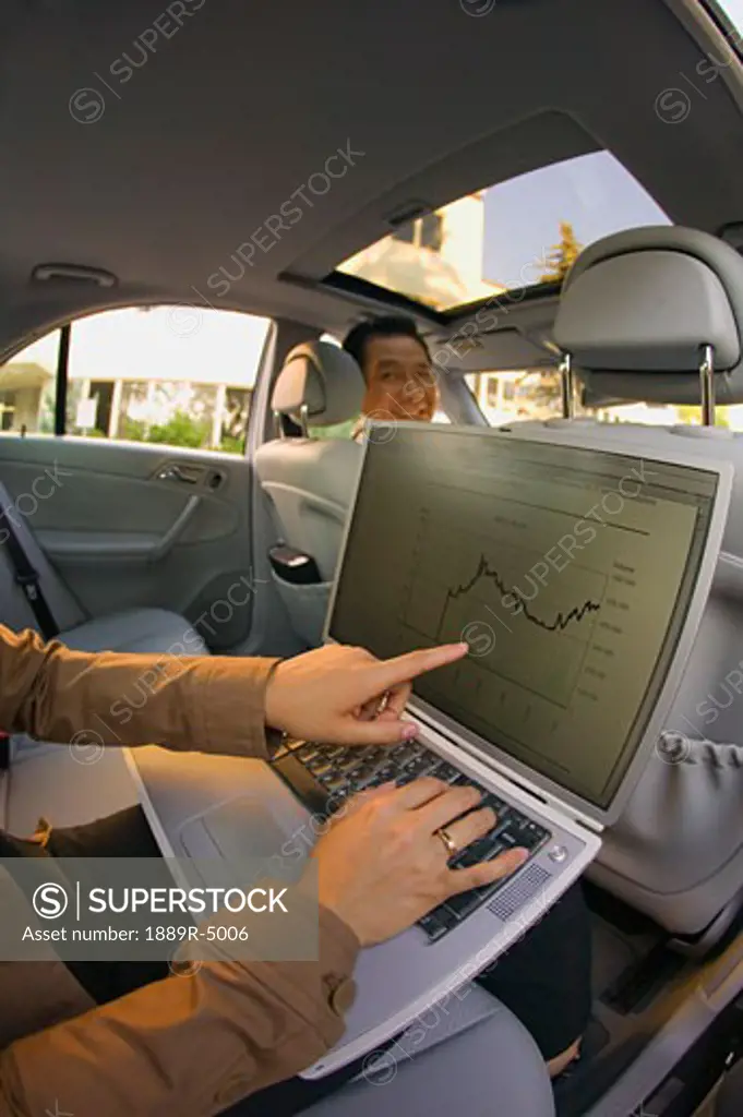 Businesswoman on a laptop in a car
