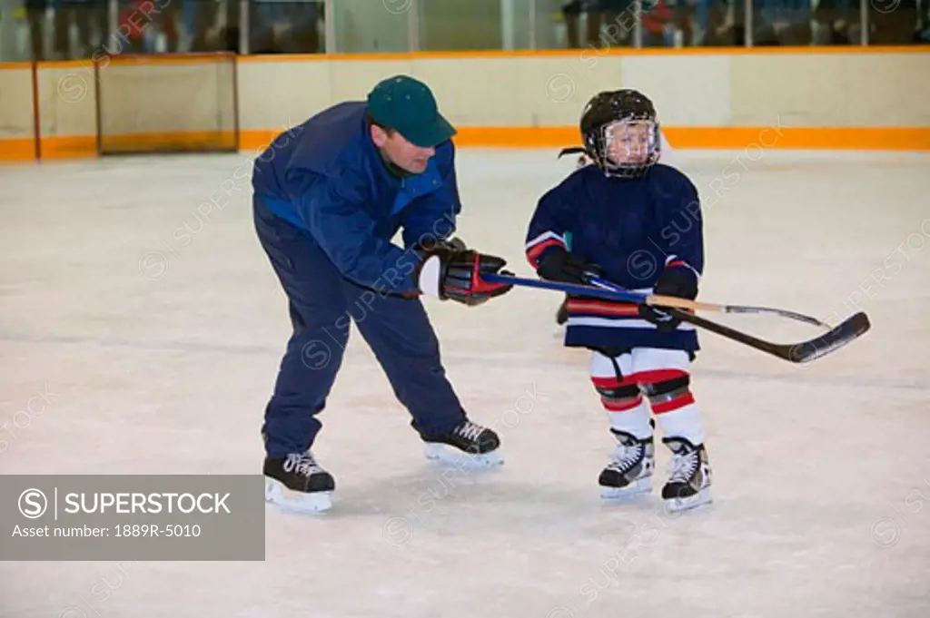 A coach and hockey player on the ice