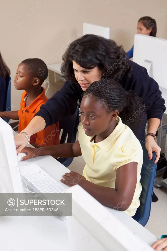teacher helping students in computer class