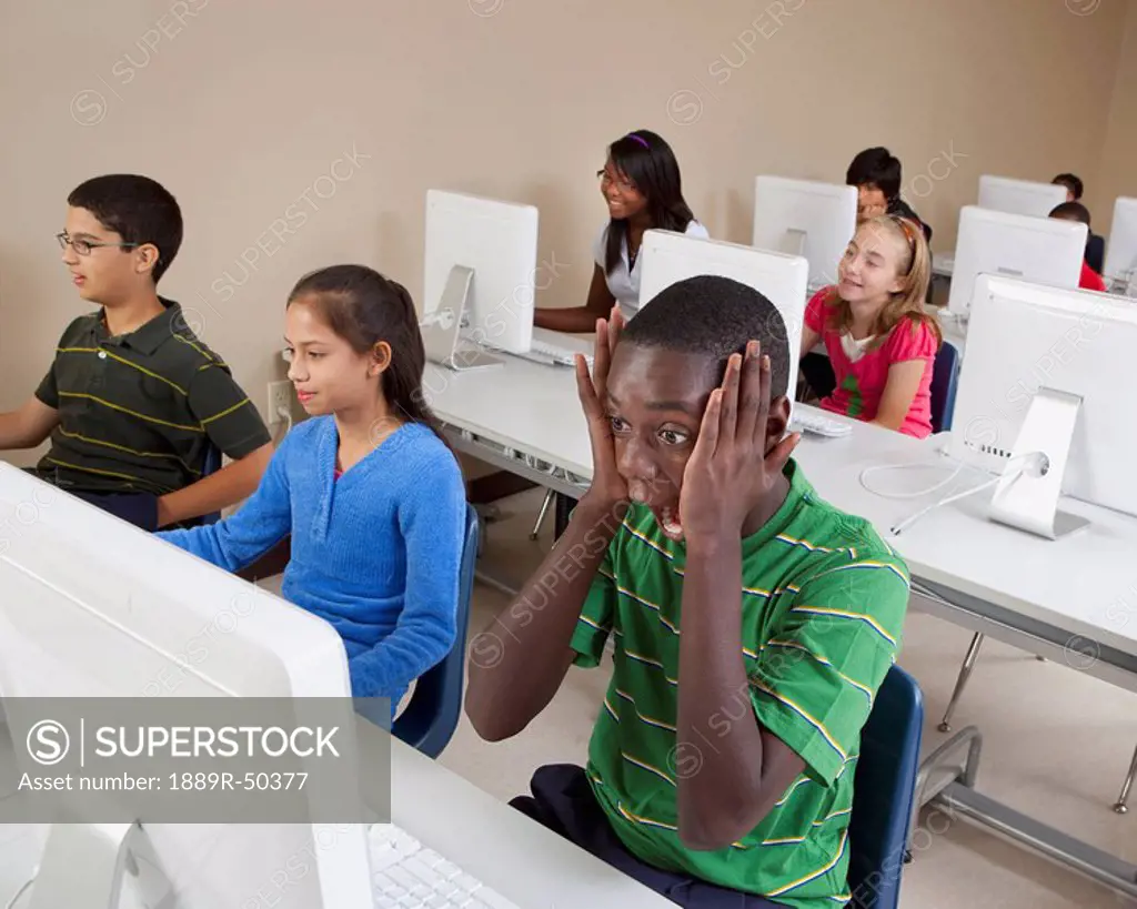 student surprised while looking at his computer in computer class