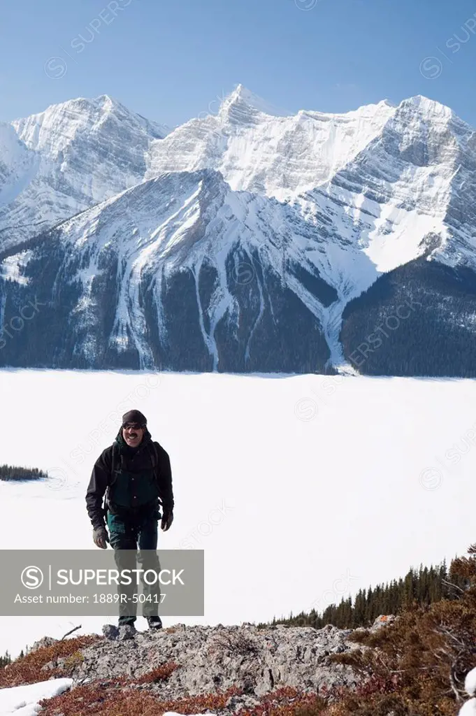 kananaskis country, alberta, canada, a male hiker in winter with snow_covered mountains and upper kananaskis lake
